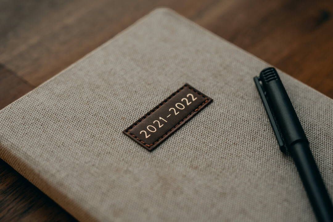 2021/2022 journal with black pen sat on a wooden table