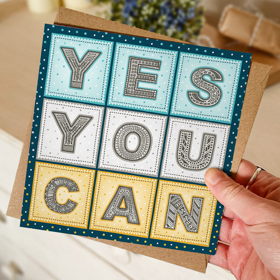 Hand holding yes you can inspiring card with recycled kraft brown envelope Unique typographic blue and yellow mental health card featuring hand-drawn lettering and positive yes you can message Printed on FSC-certified card and supplied with a kraft brown recycled envelope