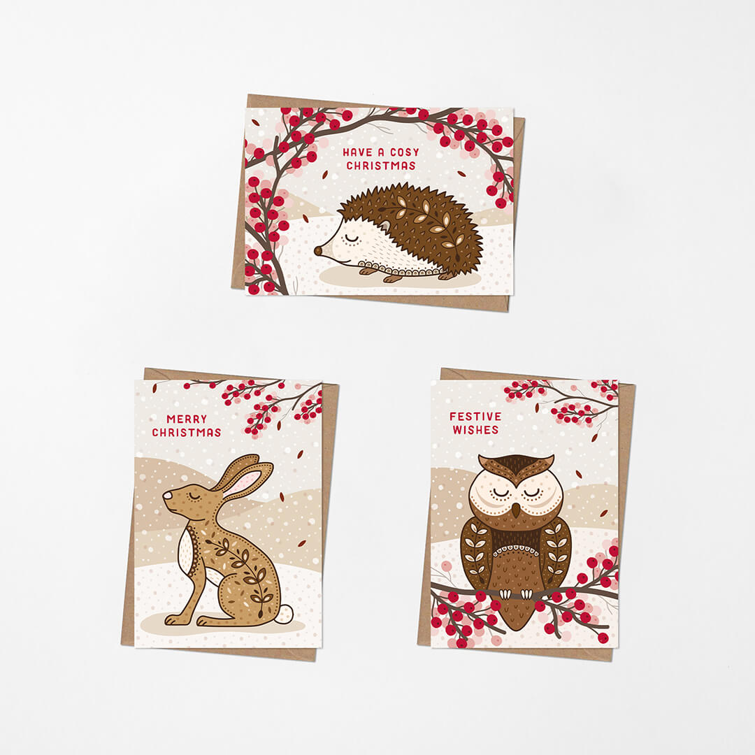 Three Christmas cards featuring hedgehog, rabbit, and owl illustrations with red berries on a white background.