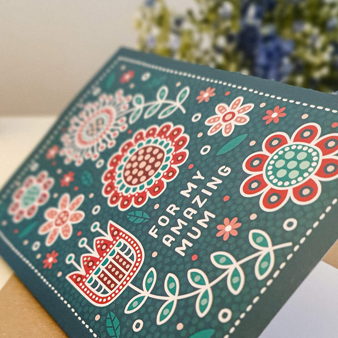 dark green and red mothers day card with floral and botanical illustrations in folk art style. Featuring 'for my amazing mum' message. Supplied with a recycled kraft brown envelope
