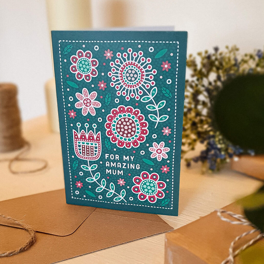 dark green and red floral mothers day card with folk art style floral illustrations and 'for my amazing mum' message. Supplied with a kraft brown recycled envelope.