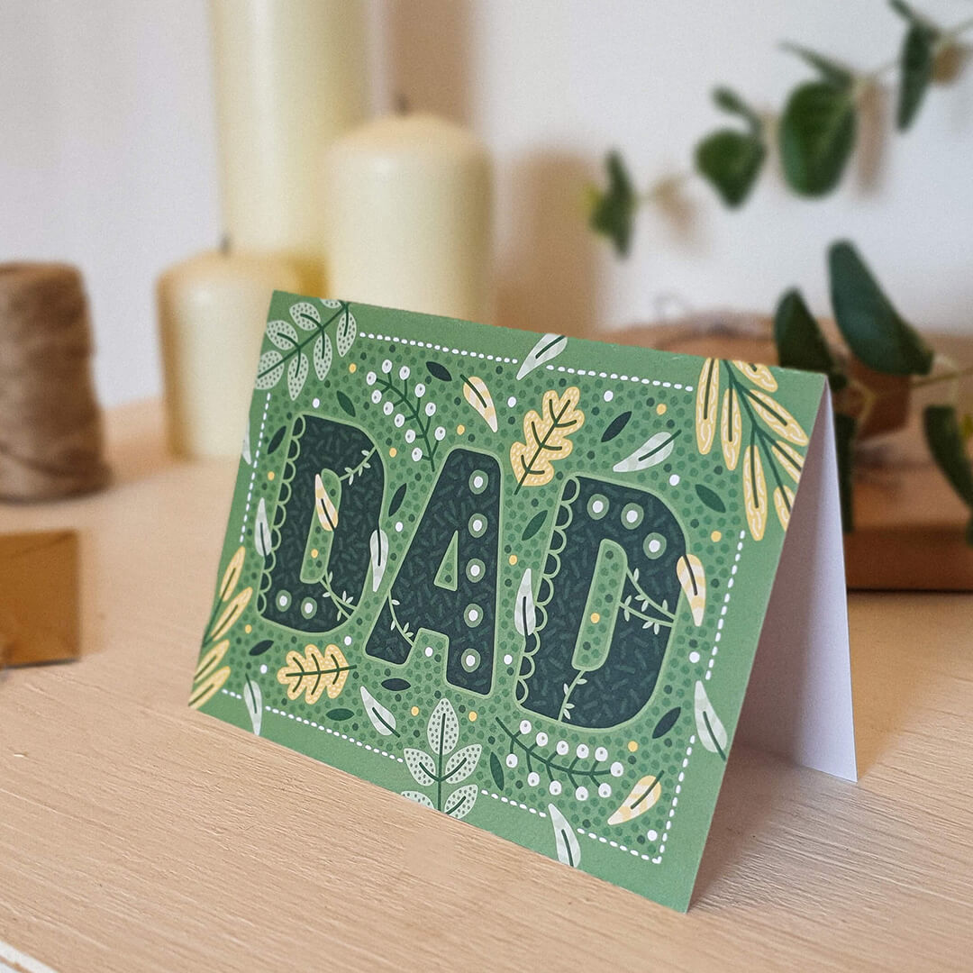 green botanical father's day card featuring leaf and botanical illustrations and 'dad' written in dark green text