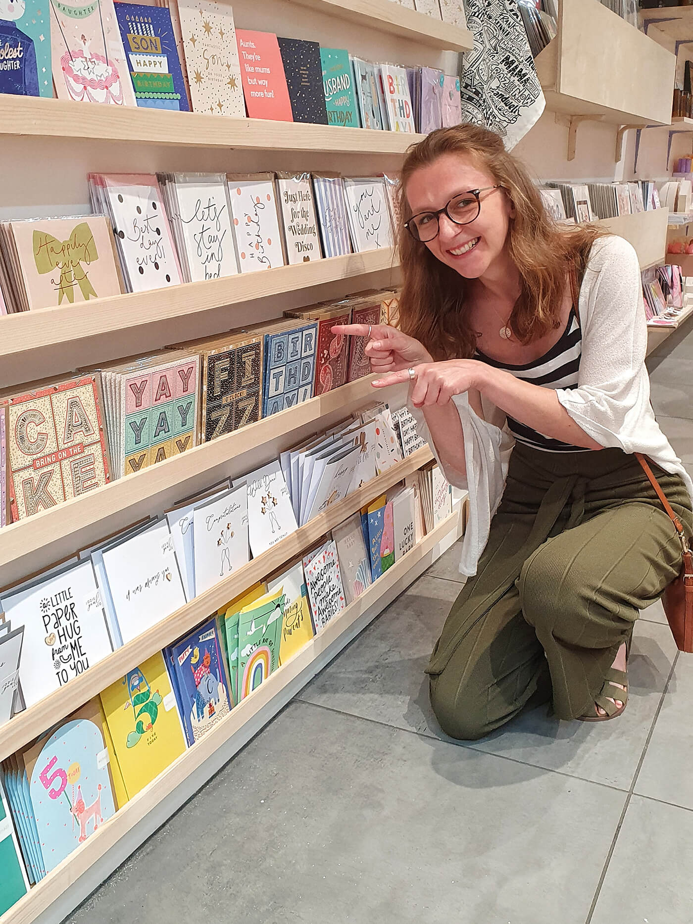 Jess stood with her greeting card designs in a high street shop