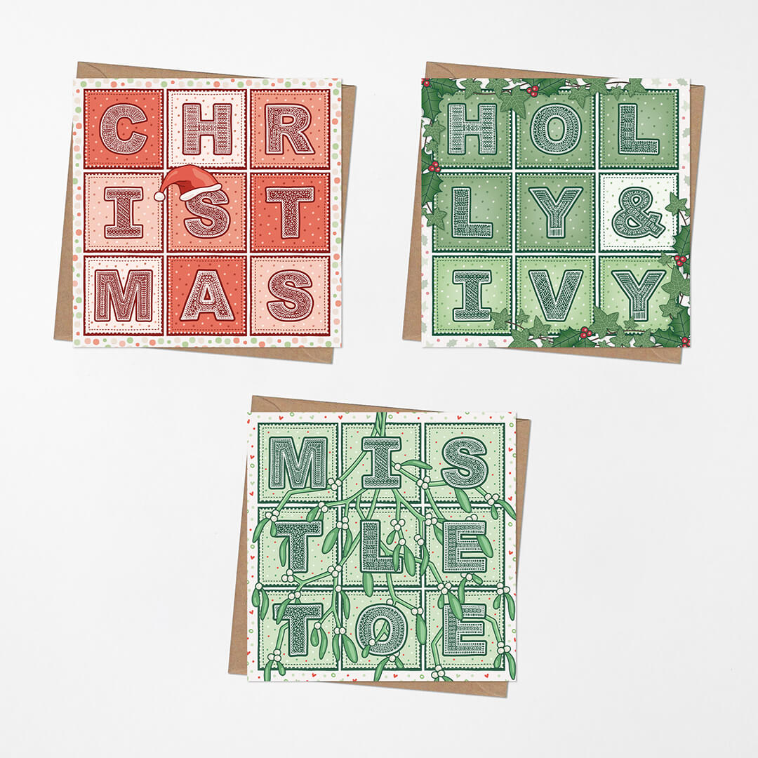 Three traditional red and green typographic Christmas cards with kraft brown envelopes on a white background.