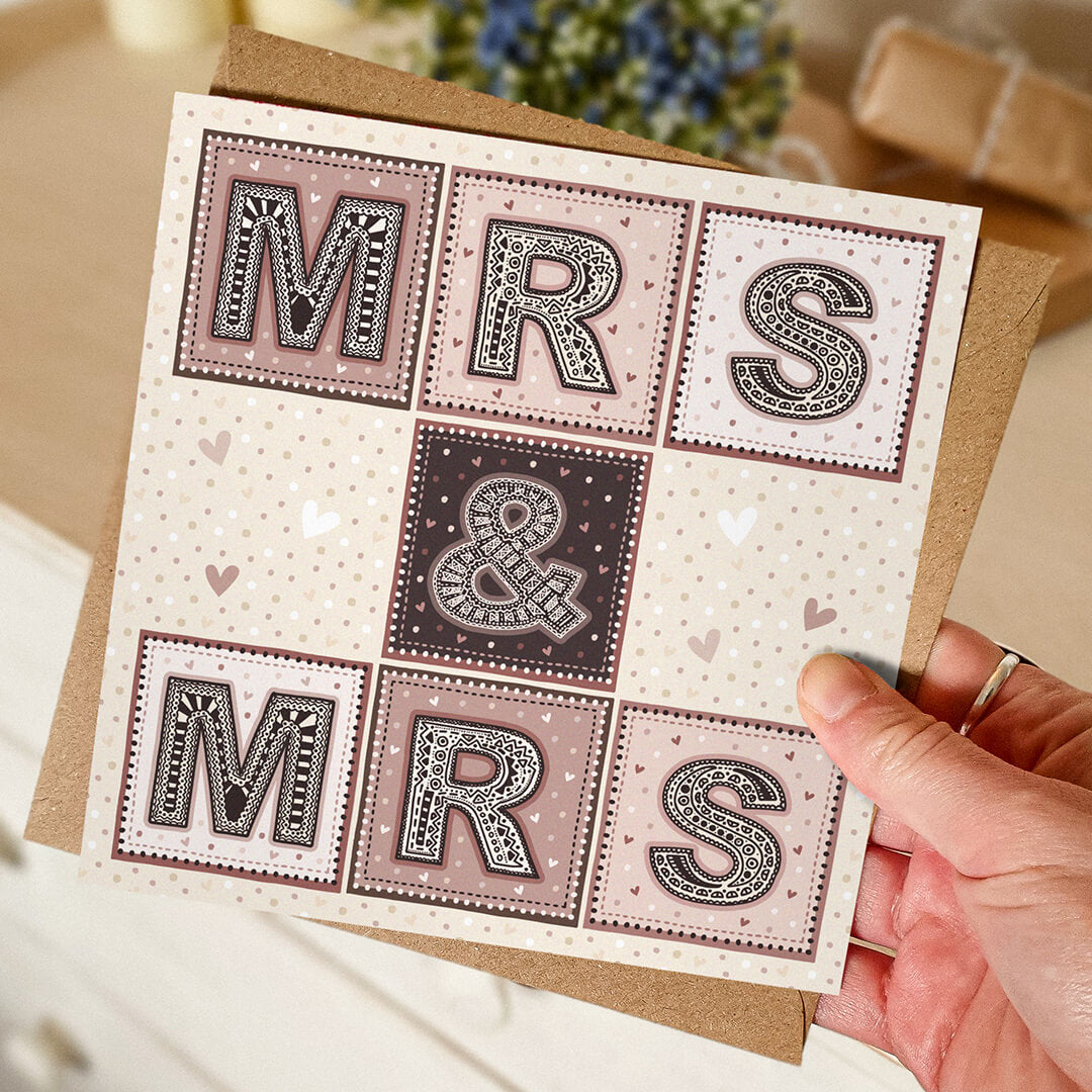 Hand holding Mrs and Mrs wedding card Unique pink cream typographic wedding card design Printed on recycled card Supplied with kraft brown recycled envelope