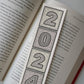 lifestyle shot showing close up of 2024 unique bookmark featuring unique 2024 illustration Printed on recycled card