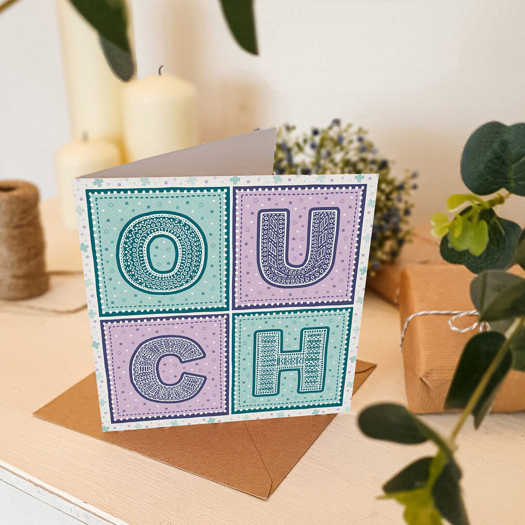 Purple and turquoise ouch get well soon card Colourful unique typographic get well soon card Printed on FSC-certified card with a recycled kraft brown envelope Blank inside