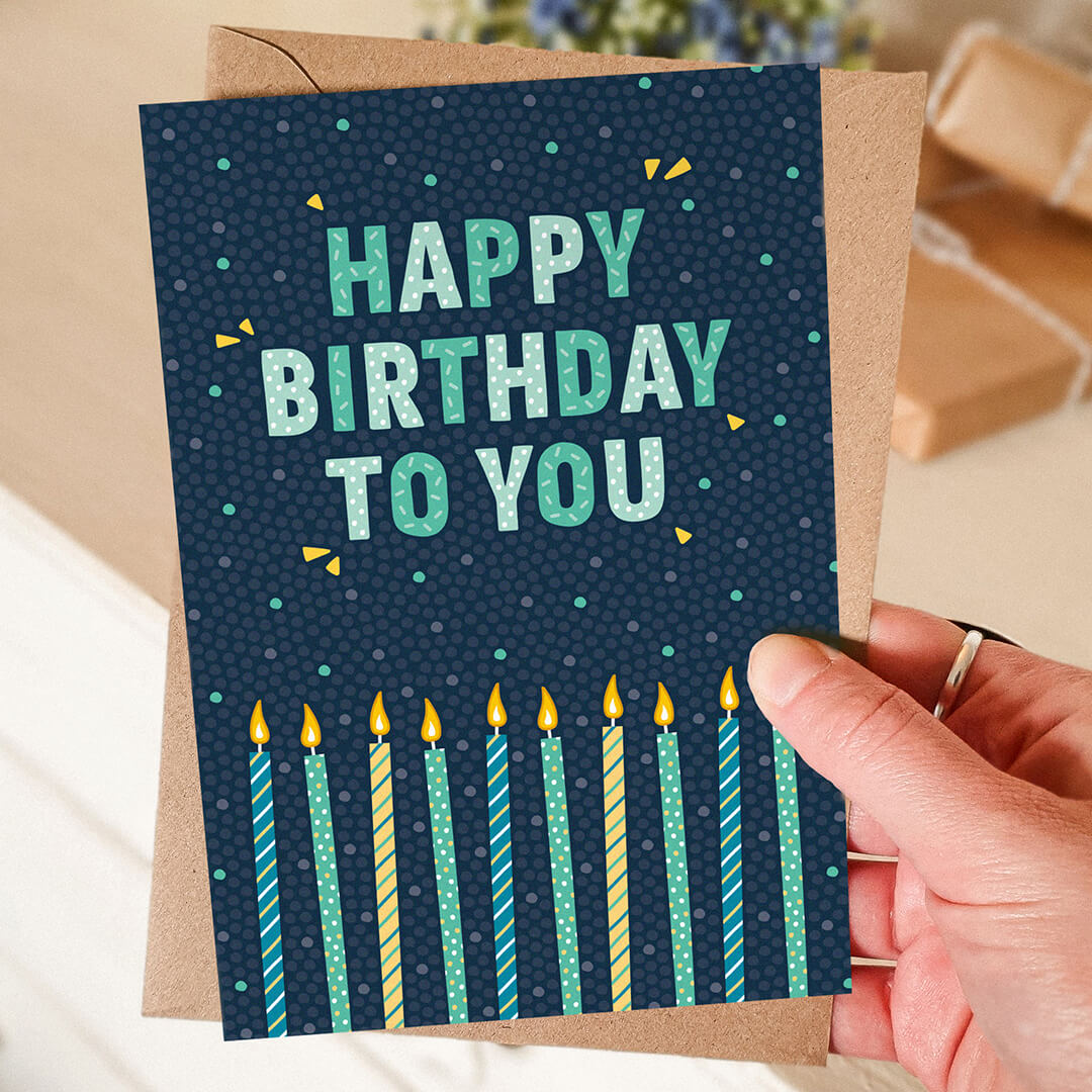 hand holding blue and green candles birthday card typographic birthday card for men Printed on FSC-certified card and supplied with a recycled kraft brown envelope