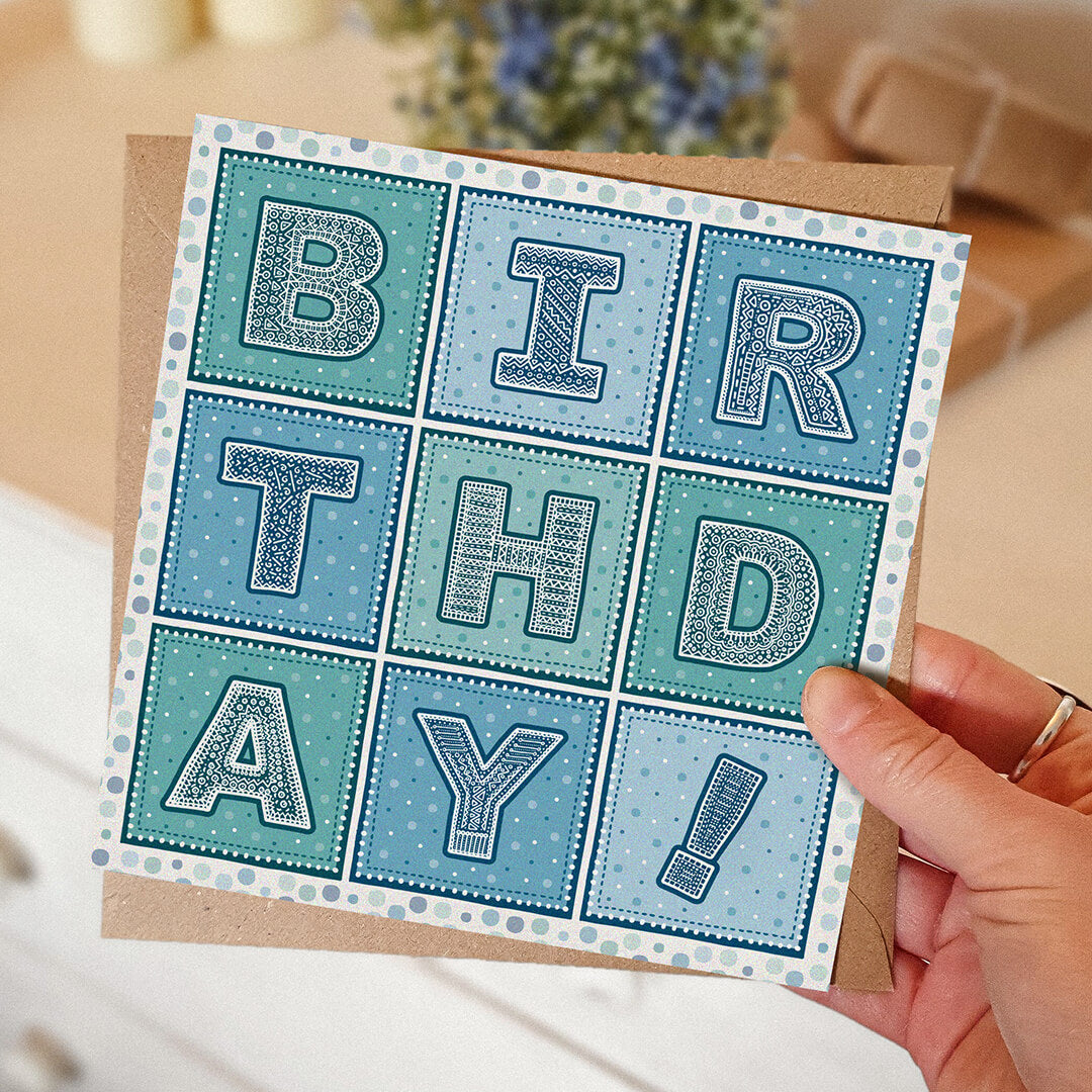 Hand holding unique blue and turquoise typographic birthday card Printed on FSC-certified card with kraft brown recycled envelope Blank inside