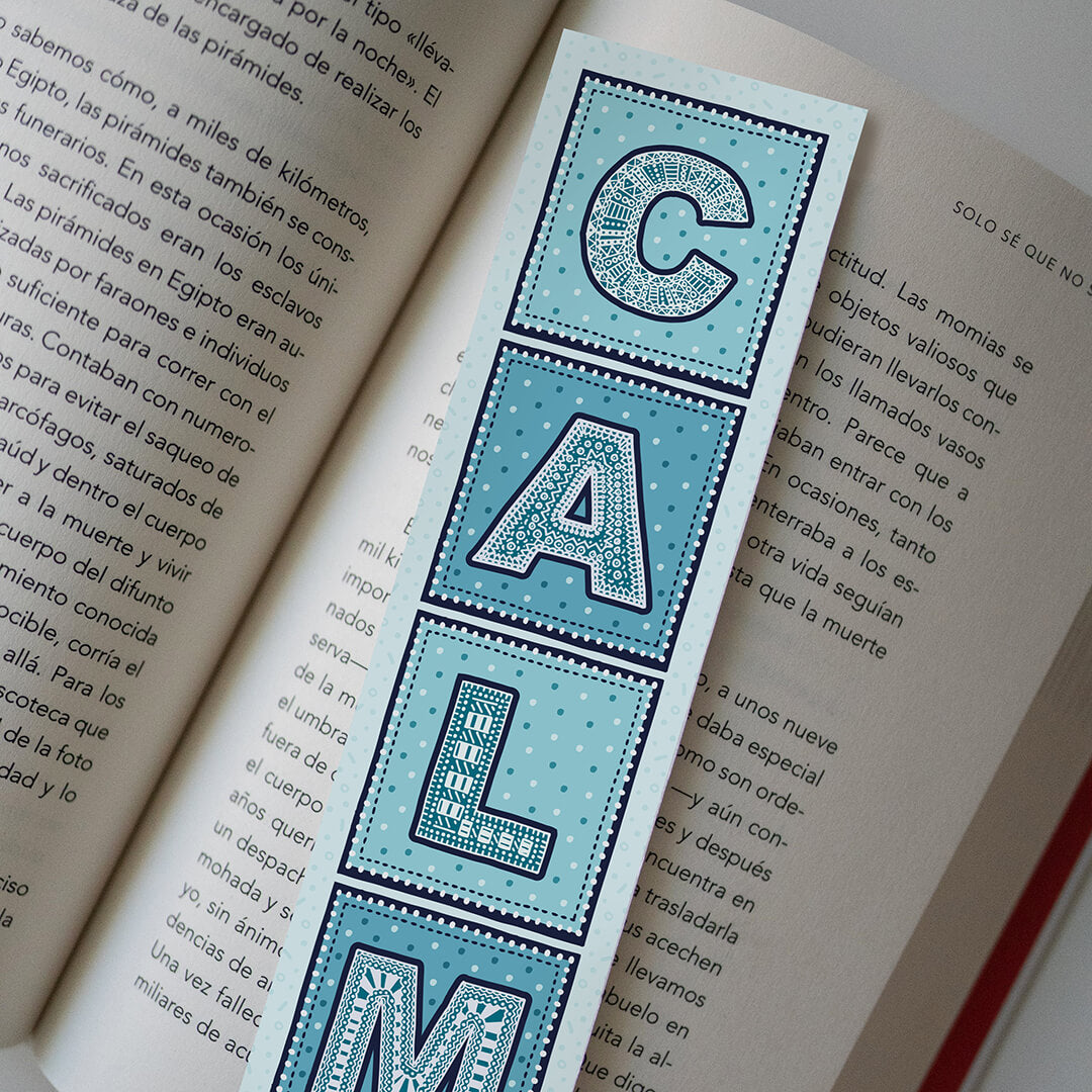 lifestyle shot showing front of mindfulness bookmark featuring typographic CALM illustration Printed on recycled card
