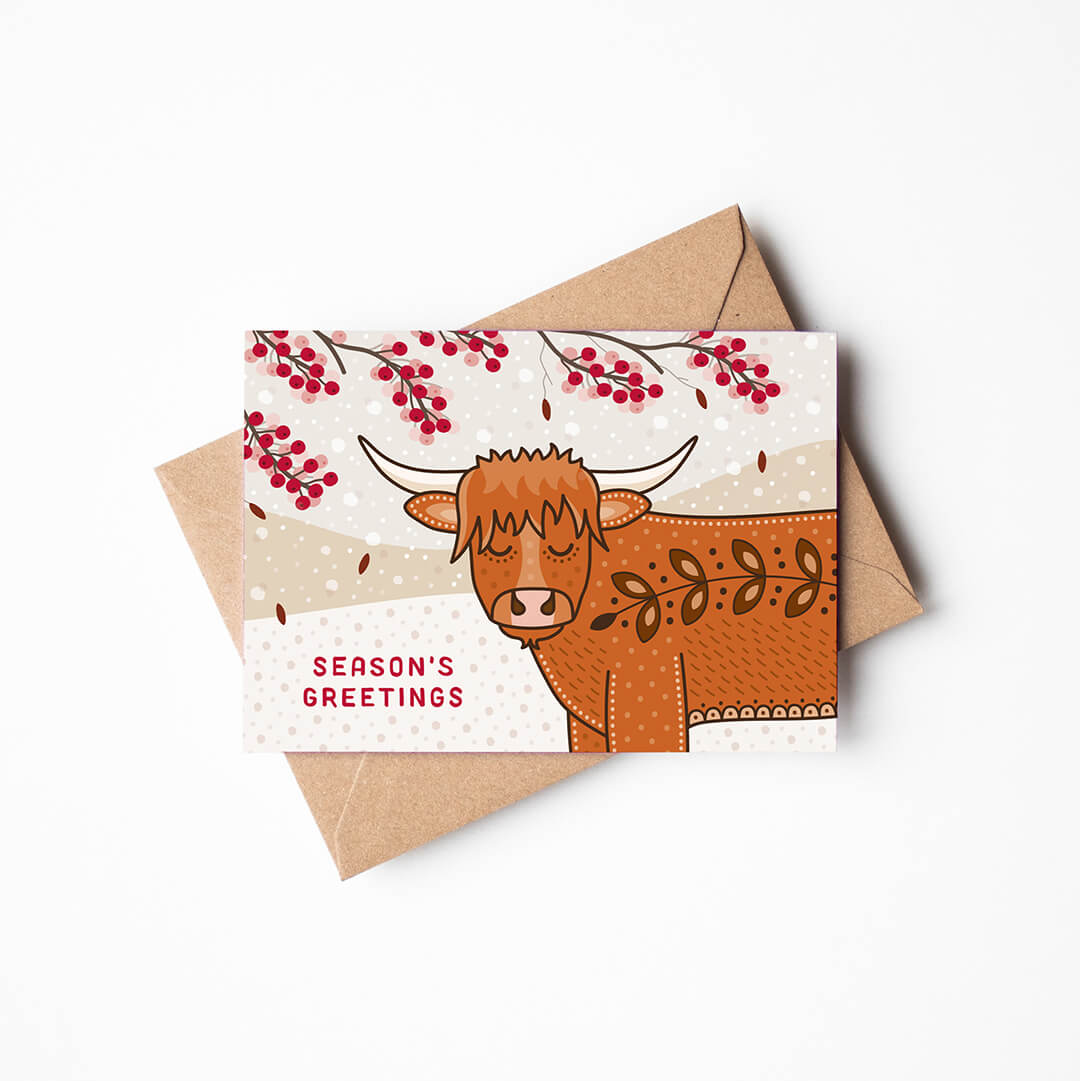 cute highland cow christmas card with recycled kraft envelope on a white background