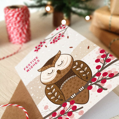 Christmas card with an owl illustration and 'Festive Wishes' message, surrounded by gifts.
