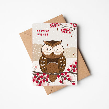 Christmas card with owl illustration and 'Festive Wishes' message, accompanied by a brown envelope on a white background.