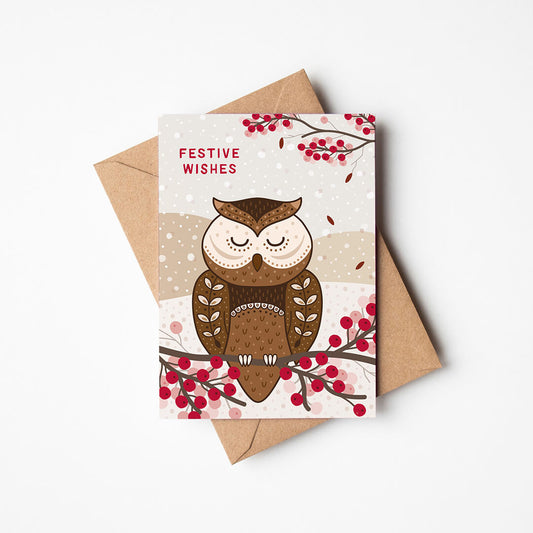 Christmas card with owl illustration and 'Festive Wishes' message, accompanied by a brown envelope on a white background.