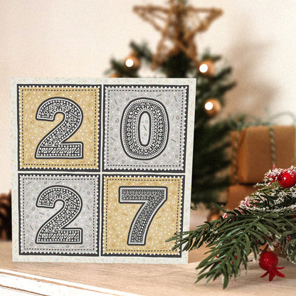 unique gold and silver 2027 new year card with blurred christmas tree in the background