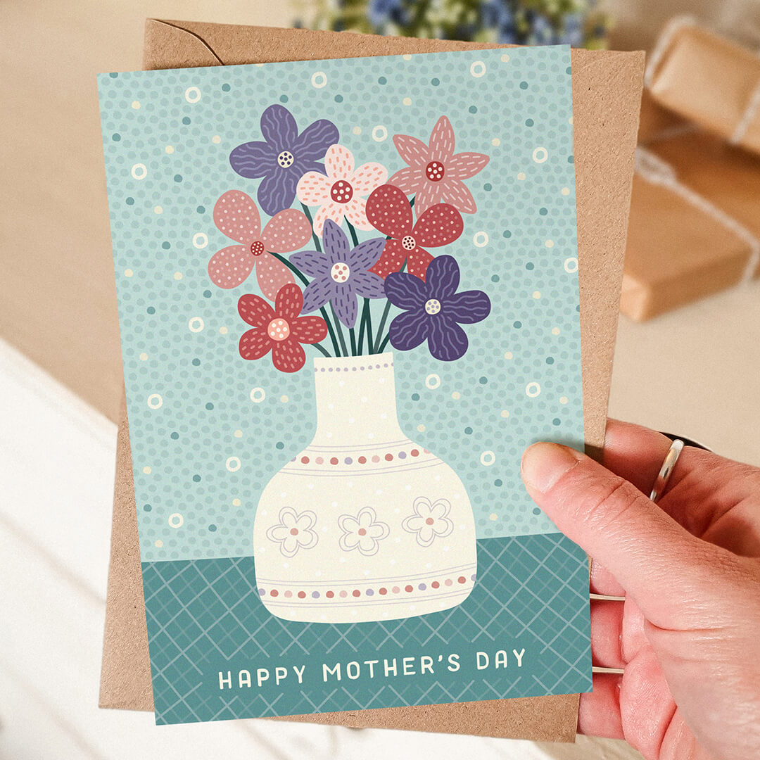 hand holding green and purple happy mother's day card featuring illustration of pretty floral vase Printed on FSC-certified card Supplied with a recycled kraft brown envelope