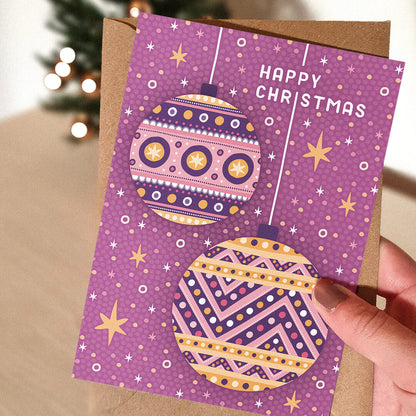 Hand holding Pink Christmas card Modern purple Baubles Christmas card design Printed on recycled card Supplied with kraft brown recycled envelope