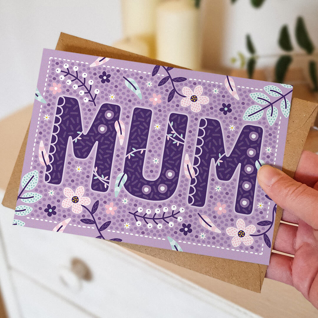 hand holding unique lilac floral botanical mum card for mother's day blank inside recycled kraft brown envelope