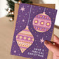 Hand holding gold and purple baubles Christmas card Modern purple Baubles Christmas card design Printed on FSC certified card Supplied with kraft brown recycled envelope