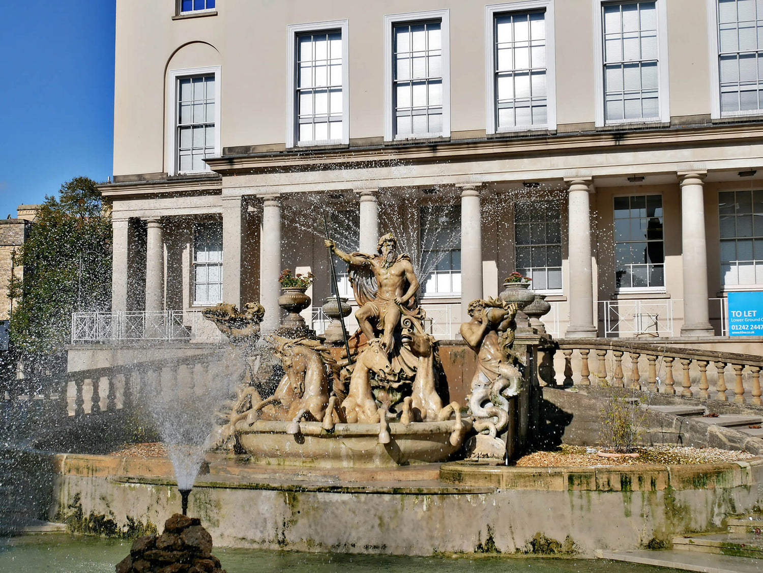 neptune fountain in cheltenham on a sunny day