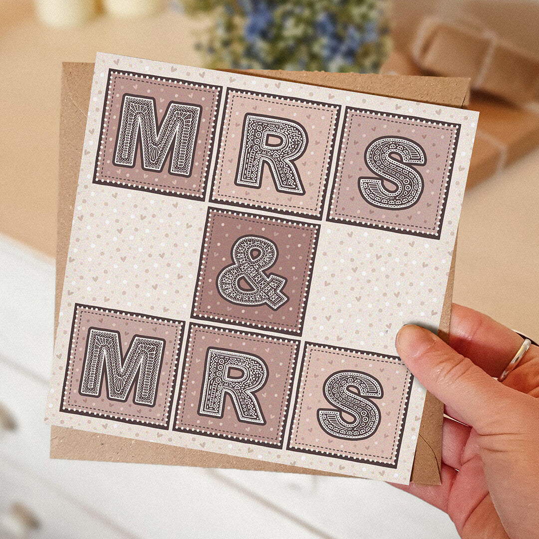 Hand holding Mrs & Mrs lesbian wedding card Unique pink cream typographic same sex wedding card Printed on FSC-certified card with kraft brown recycled envelope Blank inside