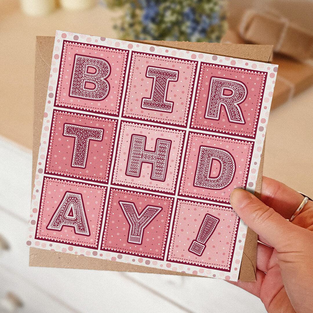 Hand holding bright and colourful typographic birthday card for her Bright pink birthday for friends and family Printed on FSC-certified card with a kraft brown recycled envelope Blank inside