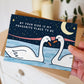 hand holding romantic valentines day card featuring two swans and a moonlit night sky and the message 'by your side is my favourite place to be' blank inside recycled kraft brown envelope