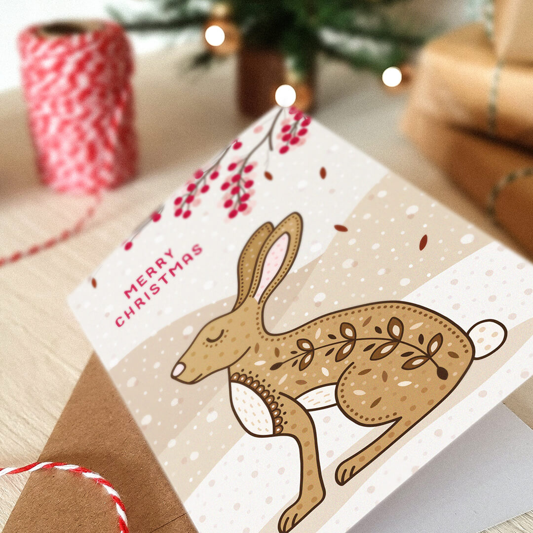 Christmas card with a hare illustration and 'Merry Christmas' message, surrounded by festive decor.