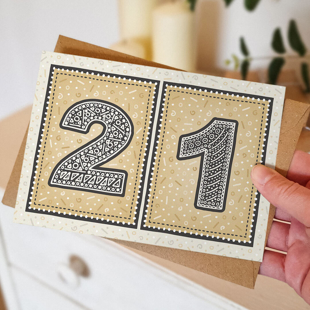 hand holding unique gold 21st birthday card with blurred background