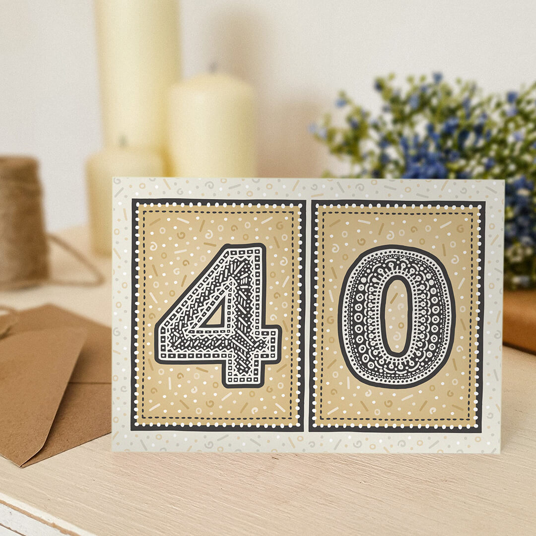 unique gold 40th birthday card with candles and flowers blurred in background
