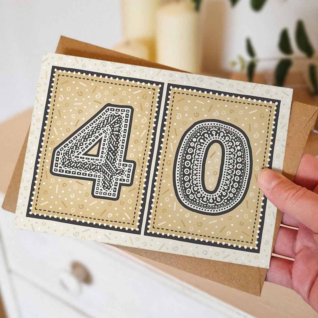 hand holding unique gold 40th birthday card with blurred background