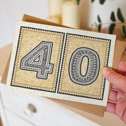 hand holding unique gold 40th birthday card with blurred background
