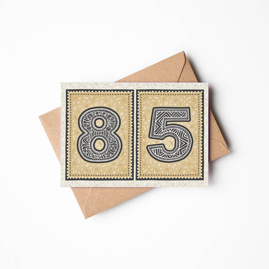 85th birthday card with a gold background and a recycled brown envelope.