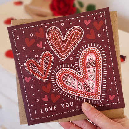 Hand holding I Love You Valentine's Day card for her Unique design with romantic heart illustration I Love You message Printed on recycled card Supplied with kraft brown recycled envelope