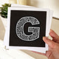 Hand holding letter G card Unique typographic greeting card Patterned black white initial greeting card Blank inside