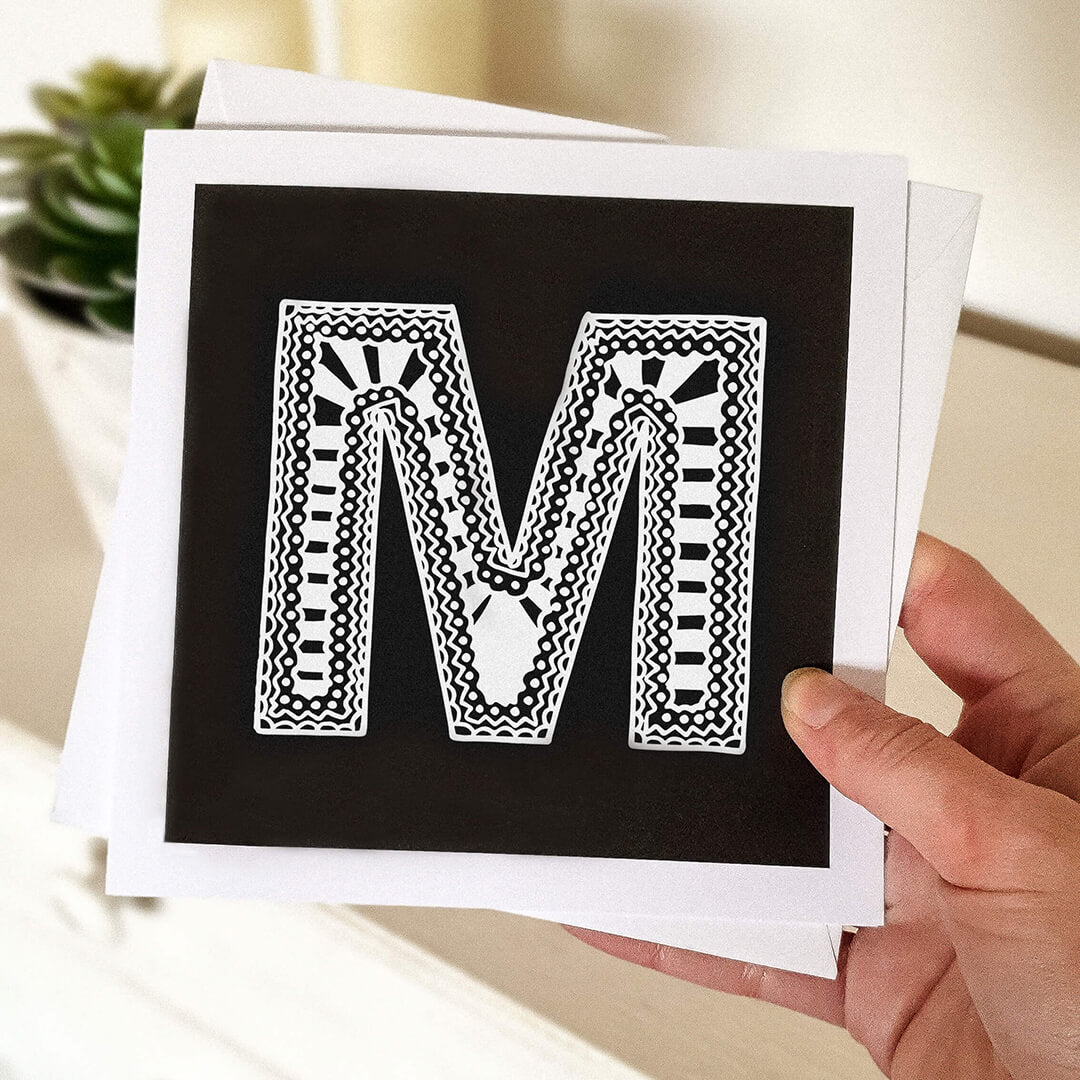 Hand holding letter M card Unique typographic greeting card Patterned black white initial greeting card Blank inside