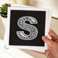 Hand holding letter S card Unique typographic greeting card Patterned black white initial greeting card Blank inside