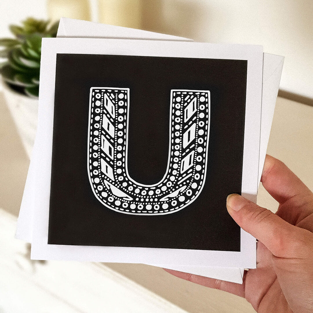 Hand holding letter U card Unique typographic greeting card Patterned black white initial greeting card Blank inside