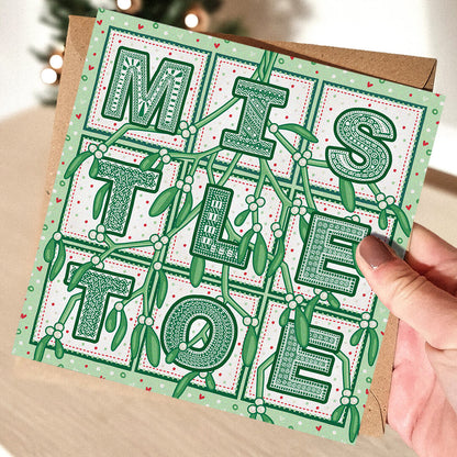 Hand holding Romantic Mistletoe Christmas card Unique typographic Christmas card design for husband or wife Printed on recycled card Supplied with kraft brown recycled envelope