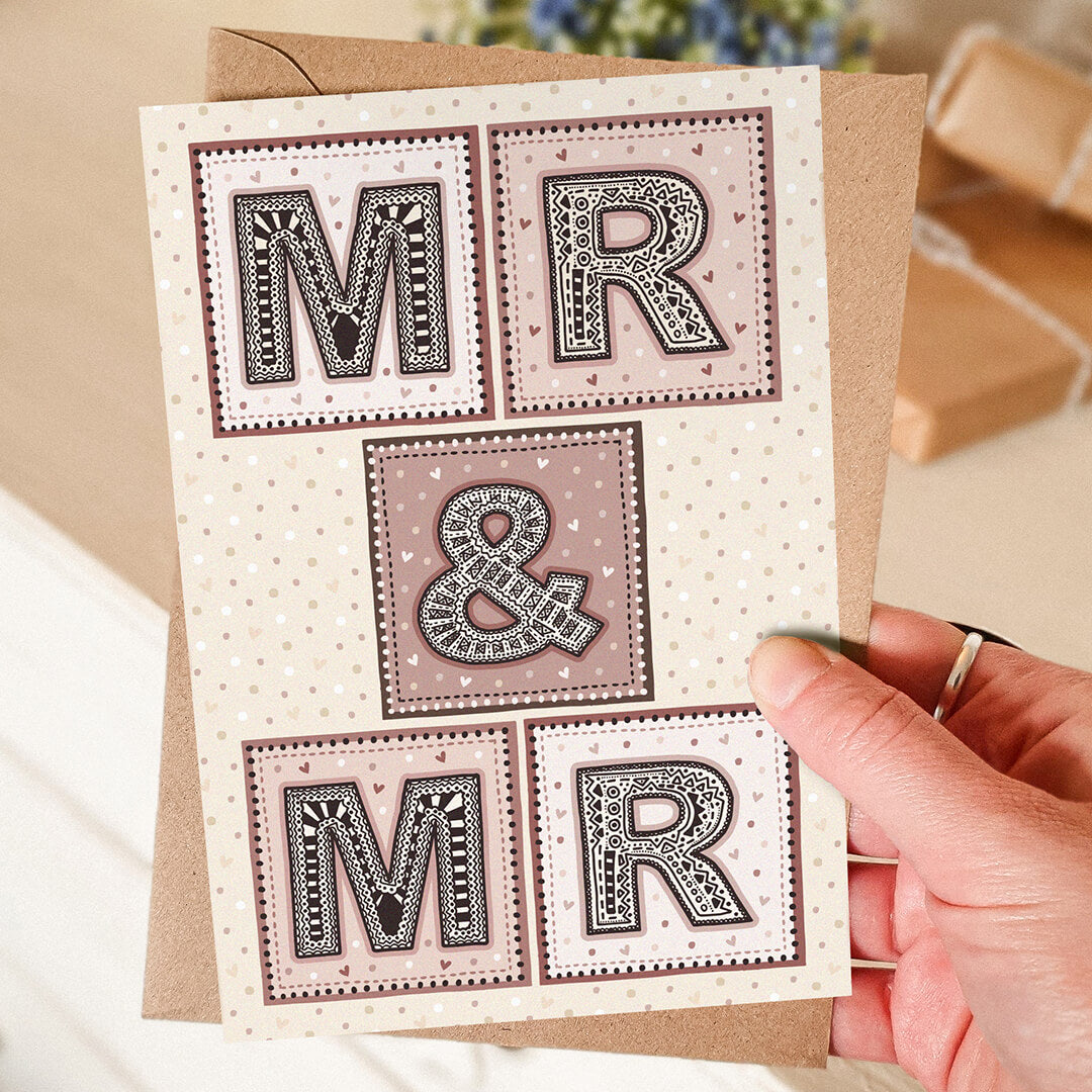 Hand holding Mr and Mr gay wedding card Unique pink cream typographic same sex wedding card Printed on recycled card Supplied with kraft brown recycled envelope