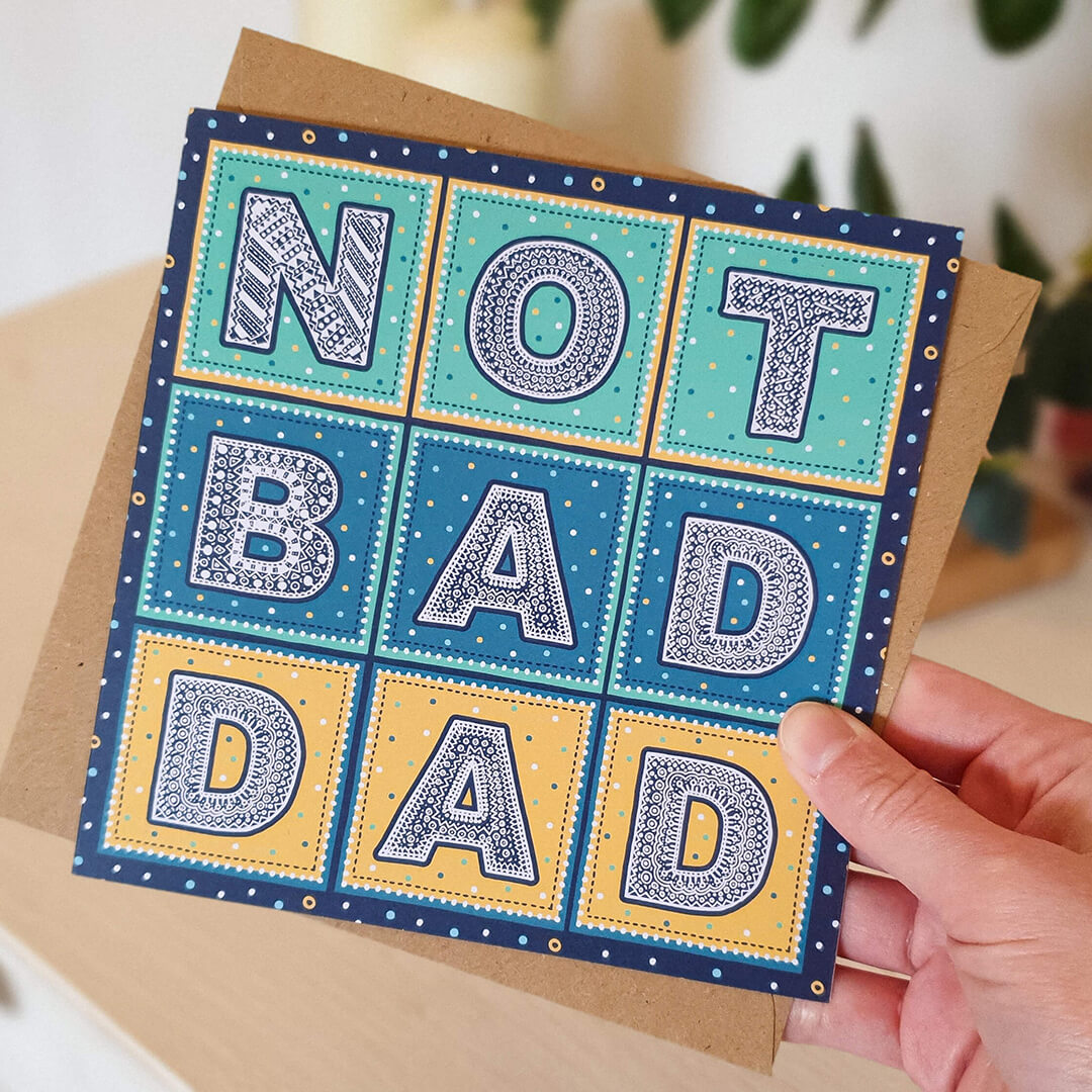 Hand holding Not Bad Dad funny Father's Day card Unique typographic colourful Father's Day card Printed on recycled card Supplied with kraft brown recycled envelope