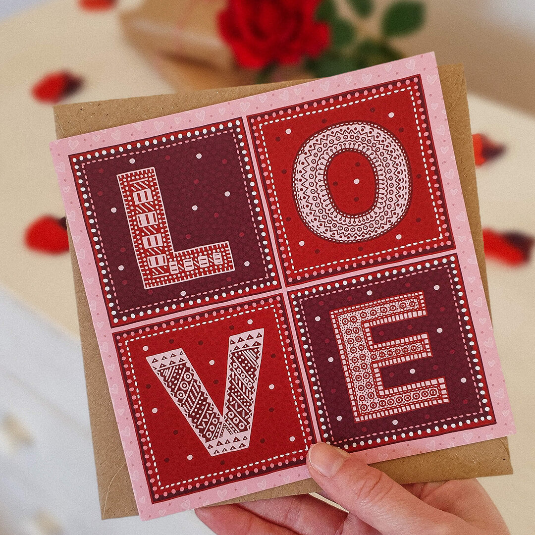 Hand holding red and pink typographic Love valentine's day card for him Unique typographic valentine's day card Printed on recycled card Supplied with kraft brown recycled envelope
