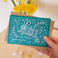 Hand holding turquoise illustrated Easter Bunny card Unique Easter card design with folk art illustrations Printed on recycled card Supplied with kraft brown recycled envelope