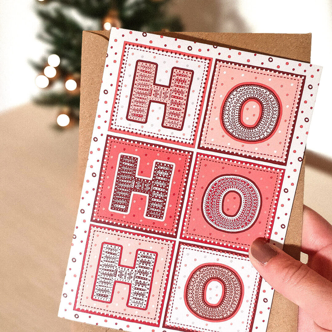 Hand holding Red white Typographic ho ho ho Christmas card Unique ho ho ho Christmas card design Printed on recycled card Supplied with kraft brown recycled envelope