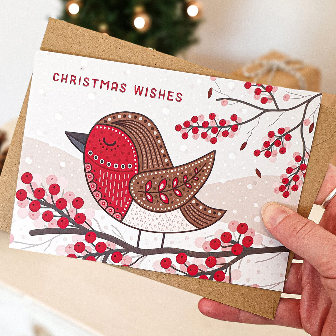 Hand holding unique illustrated robin Christmas card Cute robin Christmas card design Printed on recycled card Supplied with kraft brown recycled envelope