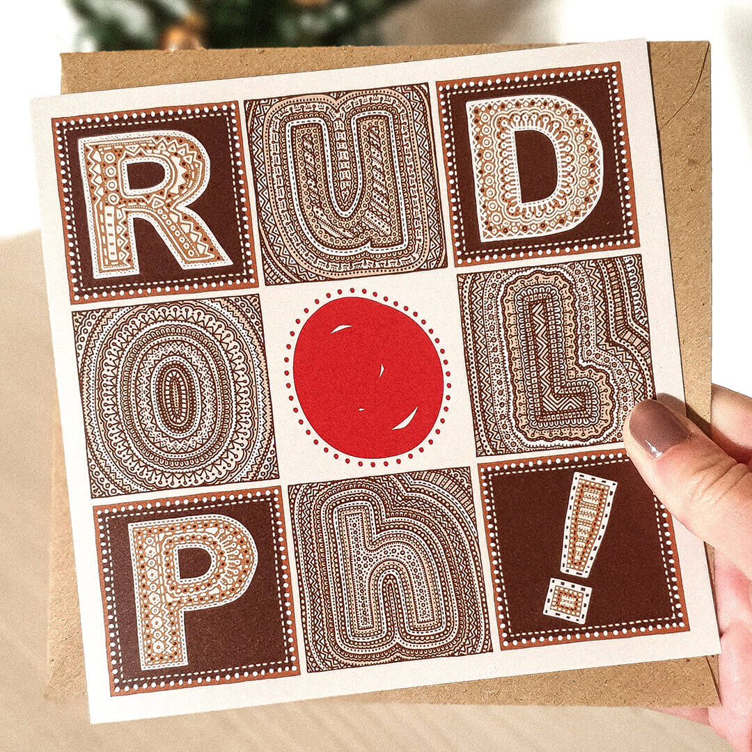 Hand holding brown red Typographic Rudolph Reindeer Christmas card Unique Rudolph Reindeer Christmas card design Printed on recycled card Supplied with kraft brown recycled envelope